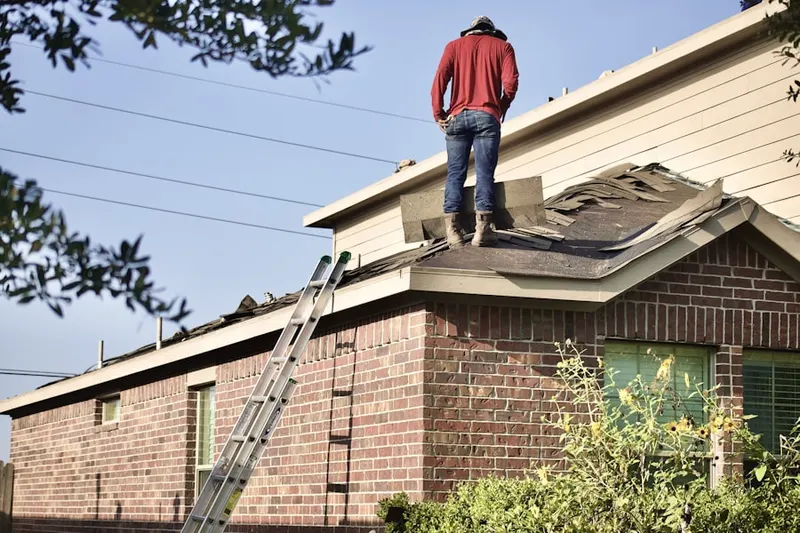 Professional roofer working on a residential roof in Gilmer